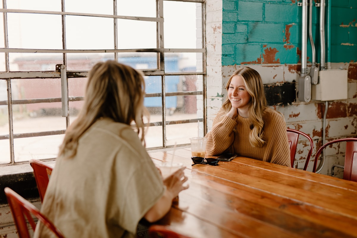 Two women talking and laughing together over coffee